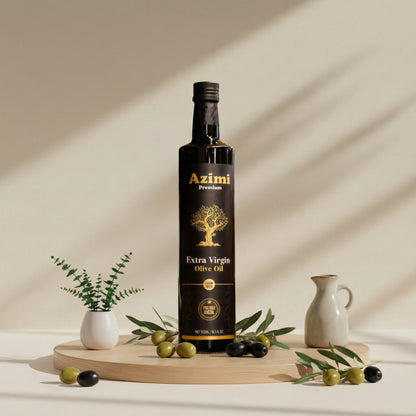 Bottle of Azimi Extra Virgin Olive Oil on a wooden board with olives and a vase on a beige background